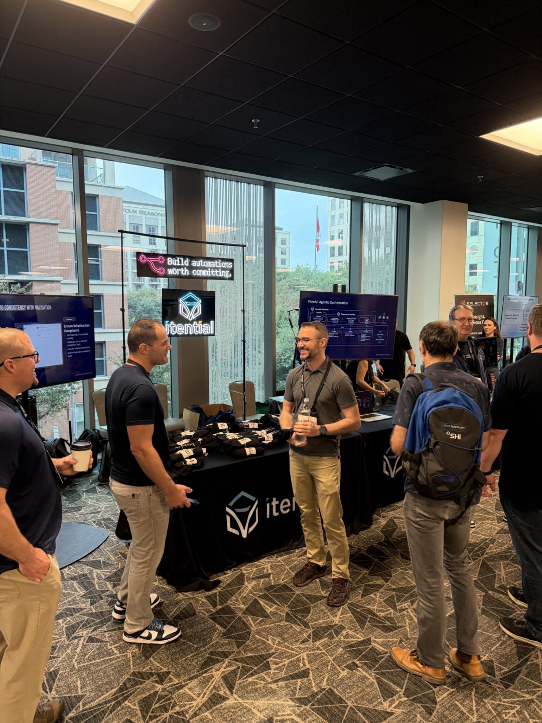 Employees chatting at Itential's booth at a conference